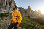 Man mountain hiking at sunset on the Dolomites: outdoor adventure
