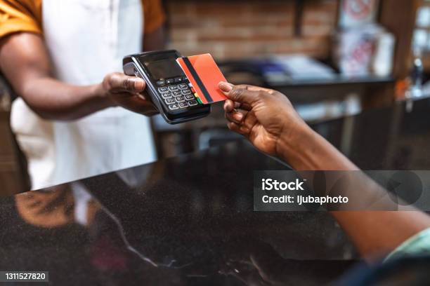 Cropped Shot Of An Unrecognizable Woman Paying For Her Purchase By Card Stock Photo - Download Image Now