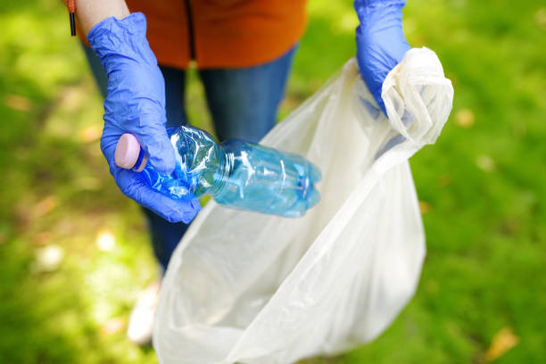 volunteer picking up the plastic garbage and putting it in biodegradable trash-bag on outdoors. ecology, recycling and protection of nature. environmental protection. - 11877 imagens e fotografias de stock