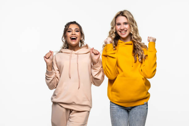 istock Two young women doing winner gesture celebrating on white background 1311527856