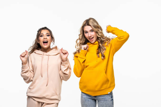 istock Two young women doing winner gesture celebrating on white background 1311528645