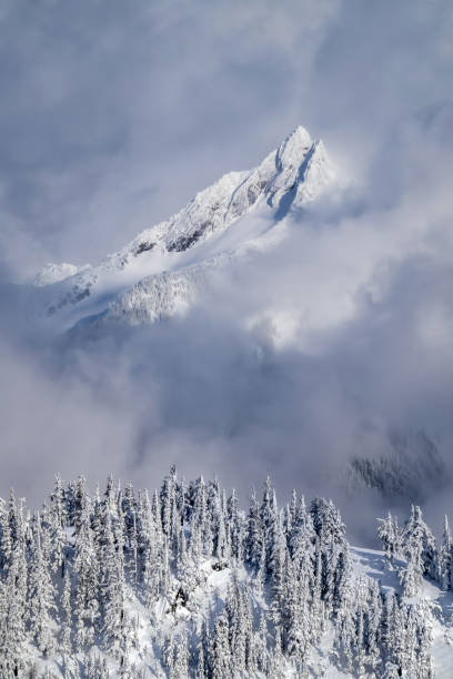 Parting Clouds Brief view of a mountain as a winter storm passes mt baker stock pictures, royalty-free photos & images