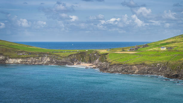 turista se relaja en pequeña playa oculta de coumeenoole entre acantilados en dingle - condado de kerry fotografías e imágenes de stock