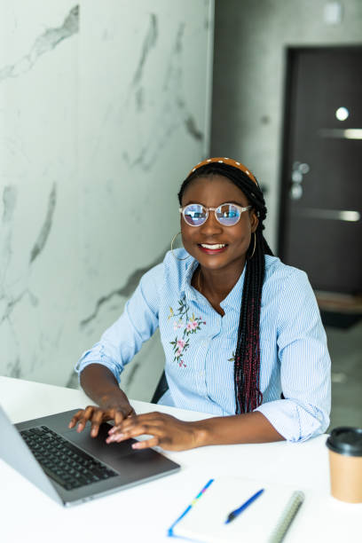 istock Attractive young african woman working on laptop while sitting at the kitchen 1311532732
