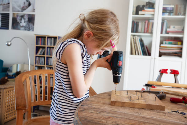 istock Girl doing DIY project with electric screwdriver 1311534539