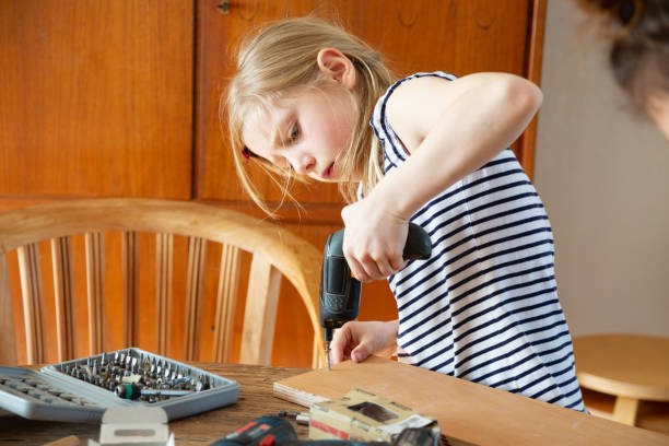 istock Girl doing DIY project with electric screwdriver 1311534615