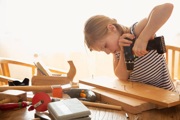 istock Girl doing DIY project with electric screwdriver 1311534634