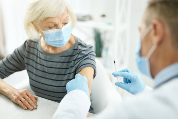 istock Doctor cleaning patient arm with alcohol swab before injection 1311536021