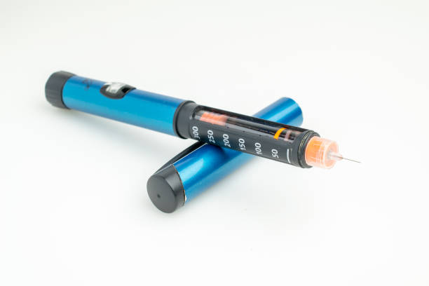 insulin pen. ampoule with a needle on a pastel green wallpaper. syringe