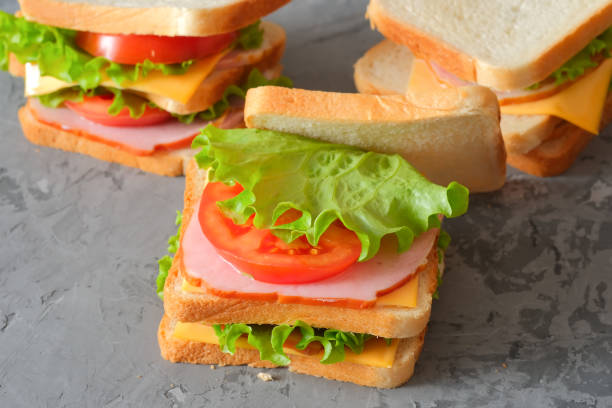istock Three tasty sandwiches on rustic wooden background 1311542608