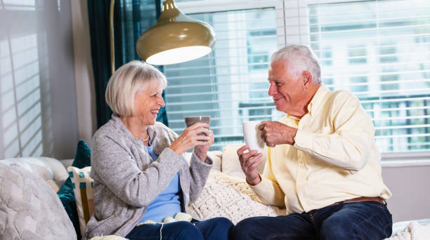 istock Senior couple on living room sofa drinking coffee or tea 1311544432