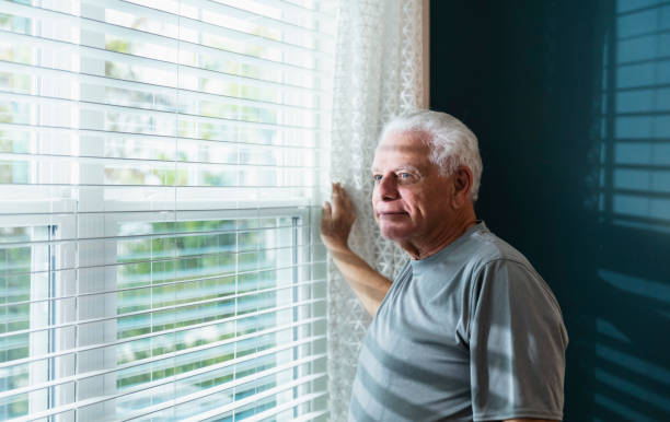 istock Senior man at home, looking out window 1311544545