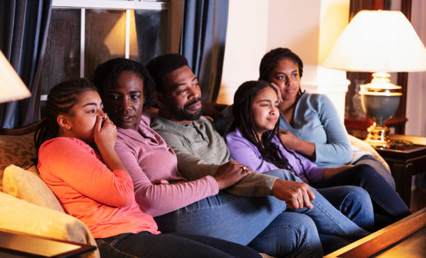 istock African-American family with three daughters watching TV 1311544656