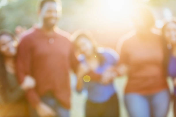 Defocused African-American family outdoors Defocused portrait of an African-American family standing together side by side outdoors, in their backyard. five people photos stock pictures, royalty-free photos & images