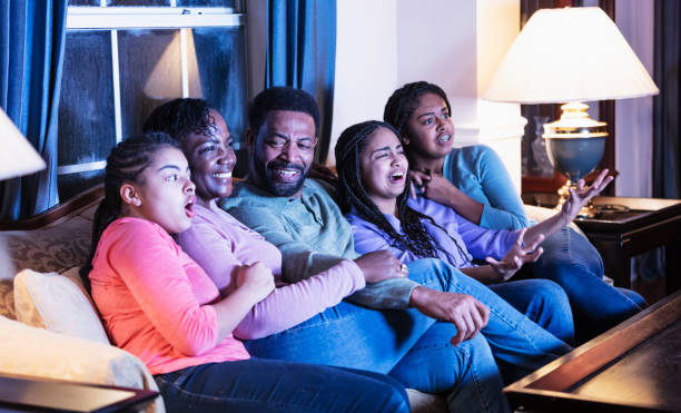 istock African-American family with three daughters watching TV 1311544683