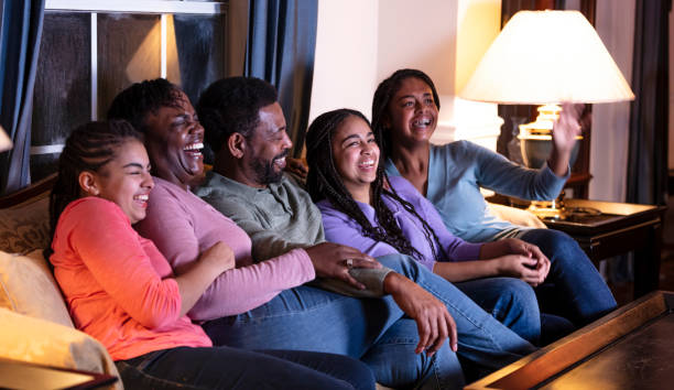 istock African-American family with three daughters watching TV 1311544837