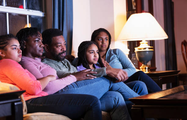 istock African-American family with three daughters watching TV 1311544905