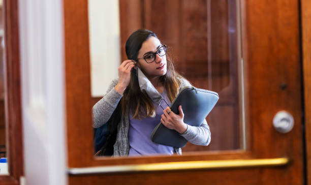 istock Young woman puts on face mask before entering room 1311544921