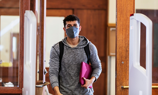 Man walking through door and anti-theft gate, face mask
