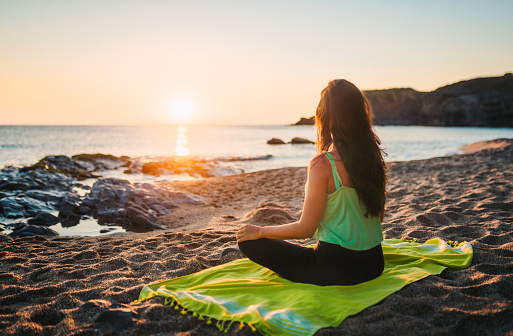 Woman doing yoga at sunrise. Tranquil scene. Active lifestyle concept.