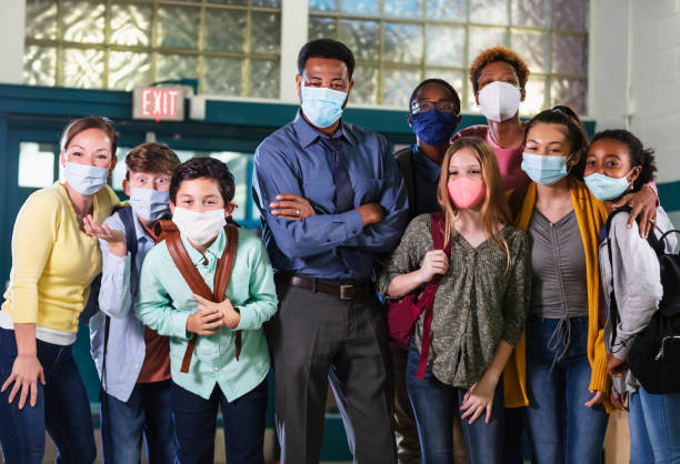 istock Teachers and middle school students standing together 1311546924