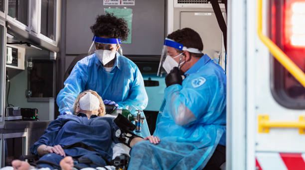 istock Patient in ambulance with paramedics, wearing face masks 1311546977