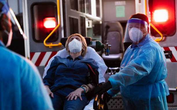istock Paramedics loading patient into ambulance, wearing PPE 1311547028