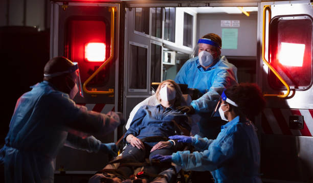 istock Paramedics loading patient into ambulance, wearing PPE 1311547035