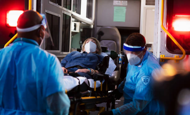 istock Paramedics loading patient into ambulance, wearing PPE 1311547116