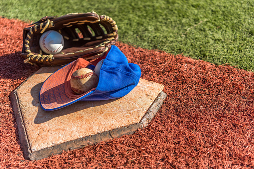 Baseball glove, bat, and ball, on grass. Baseball equipment in the field. Close-up view of baseball equipment.