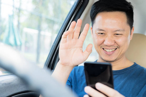 istock A young man sitting in a car holding a smartphone communicating with his girlfriends 1311558587