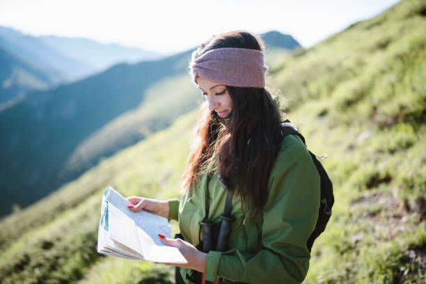 istock Female hiker looking in the map during trip. 1311562170