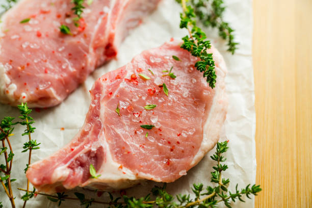 istock Raw pork meat with thyme and spices on the rustic background. Selective focus. Shallow depth of field. 1311563917