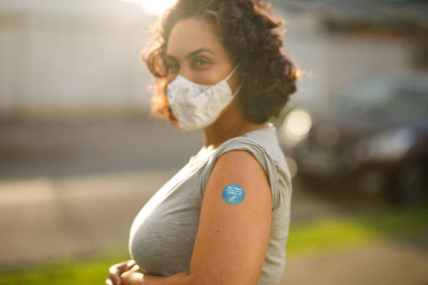 Woman showing her covid 19 vaccine badge Covid 19 vaccination vacina stock pictures, royalty-free photos & images