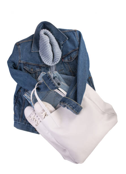 istock blue denim jacket, white leather sneakers, white bag on a white background. Clean branded clothing. Mock up for your design. Spring Summer Clothes 1311564671