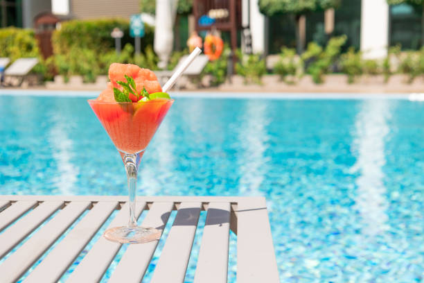 fresh red cocktail with ice in glass on swimming pool. tropical juice on luxury vacations. concept summer holiday and travel. - margarita cocktail beach fruit imagens e fotografias de stock