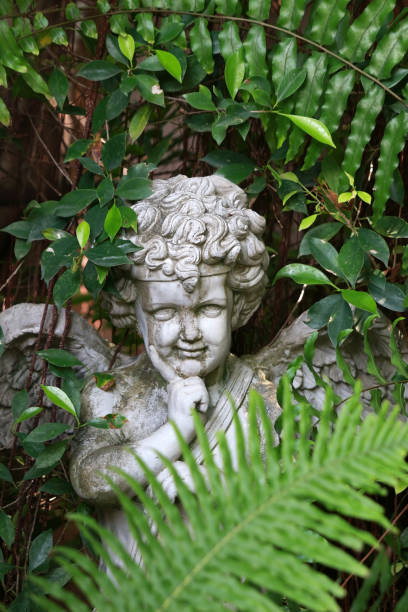 istock Angel ornament surrounded by green garden plants 1311565735