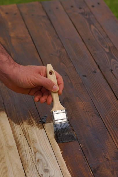 istock man paints wood in dark color 1311566587