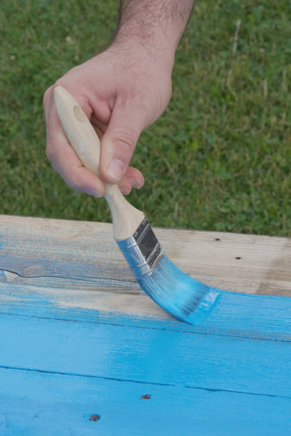 istock man paints wood in light blue 1311566599