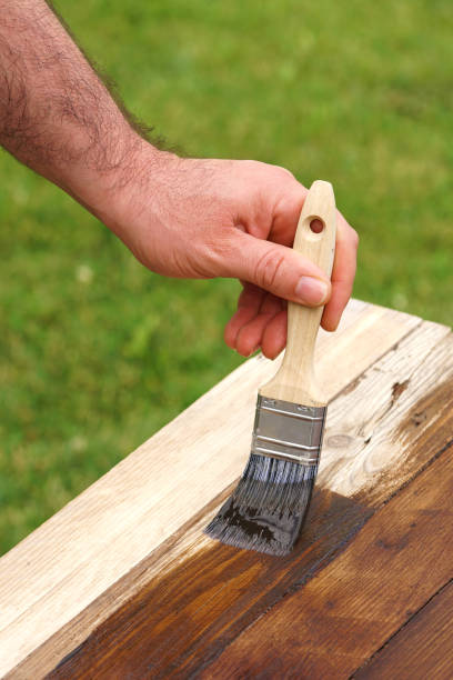 istock man paints wood in dark color 1311566603