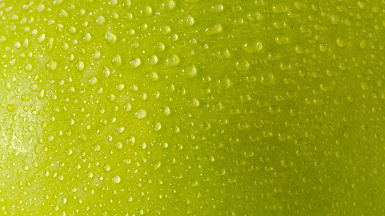 Close up water droplets on green apple skin. Macro shots image
