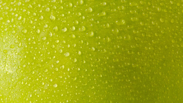 close up water droplets on green apple skin. macro shots - wet apple imagens e fotografias de stock