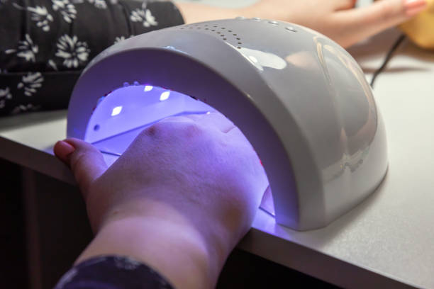 istock Hand in the LED lamp for drying the gel. 1311569186