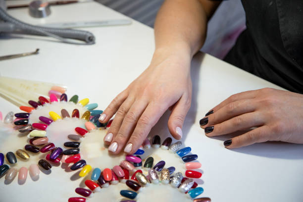 istock Female hand and palettes with varnish samples. 1311569198