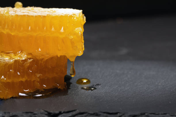 istock honey dripping from pieces of cut honeycomb 1311571748