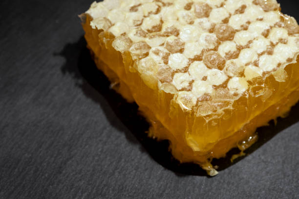 istock fresh honeycomb covered with wax on stone dark background 1311571749