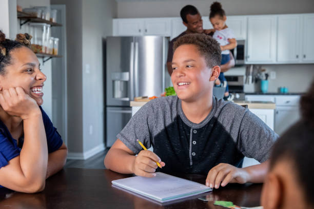 istock Teenage boy does homework at kitchen table with mother 1311573307