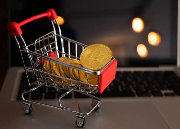 Photo of Bitcoin token in a trolley on laptop.
