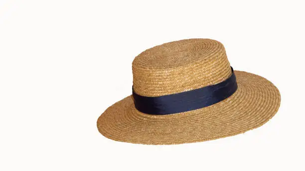 Beautiful straw hat with ribbon and bow on summer beach hat. White background from side view