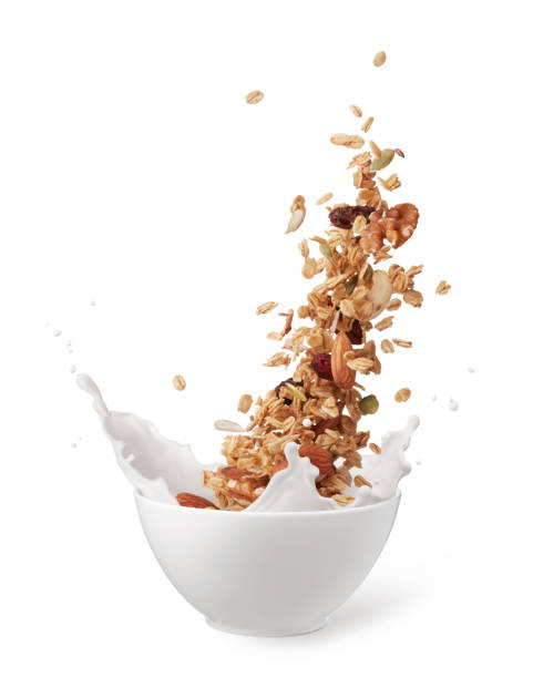 granola with milk bowl of granola with milk splashing isolated on white granola stock pictures, royalty-free photos & images